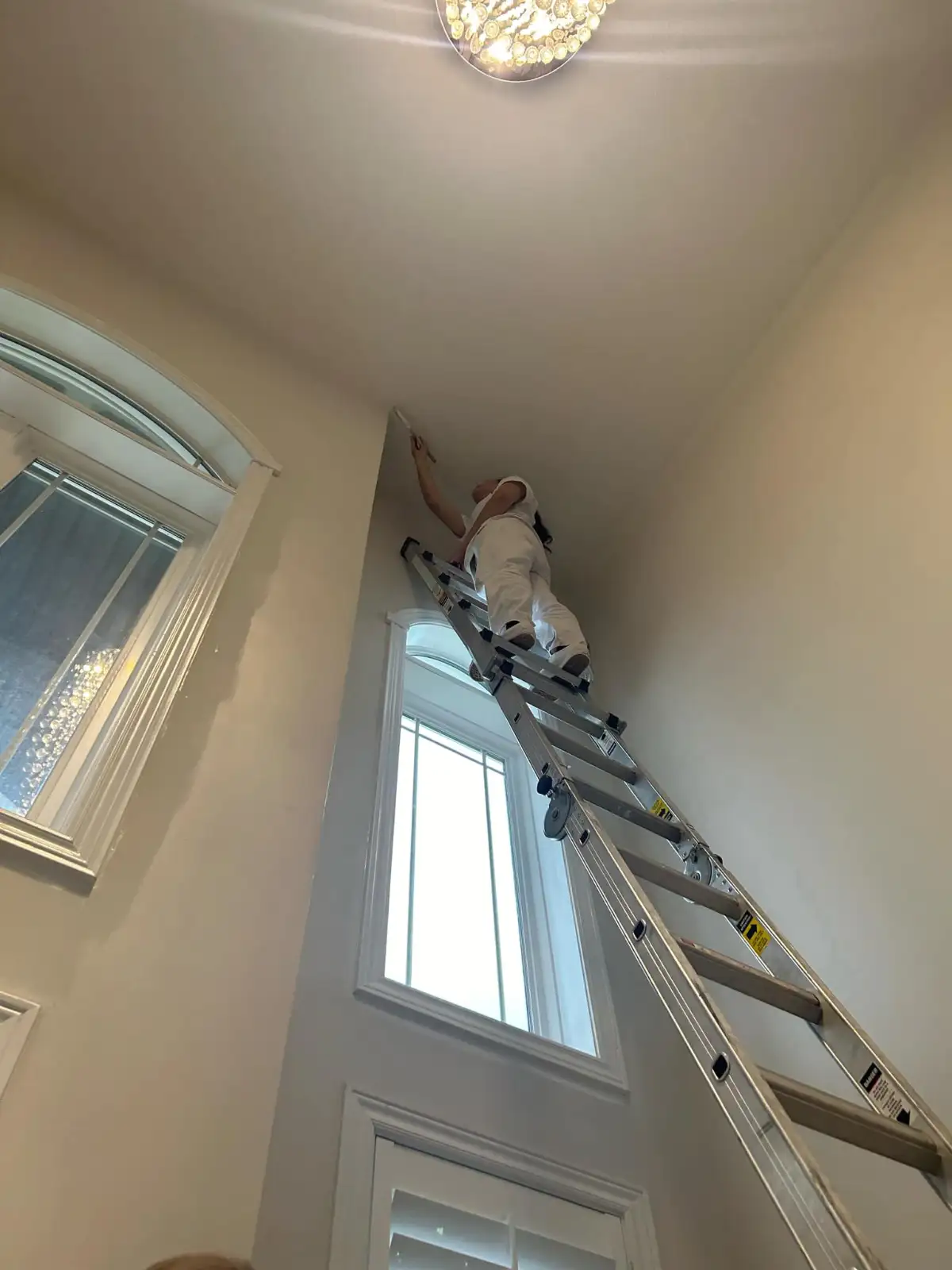 KW Pro Painters team member painting a high foyer ceiling in Kitchener, Ontario